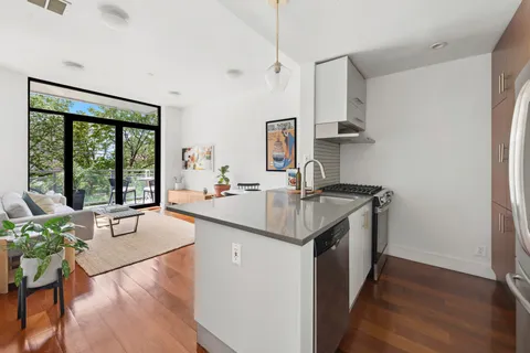 a kitchen with a sink cabinets and wooden floor