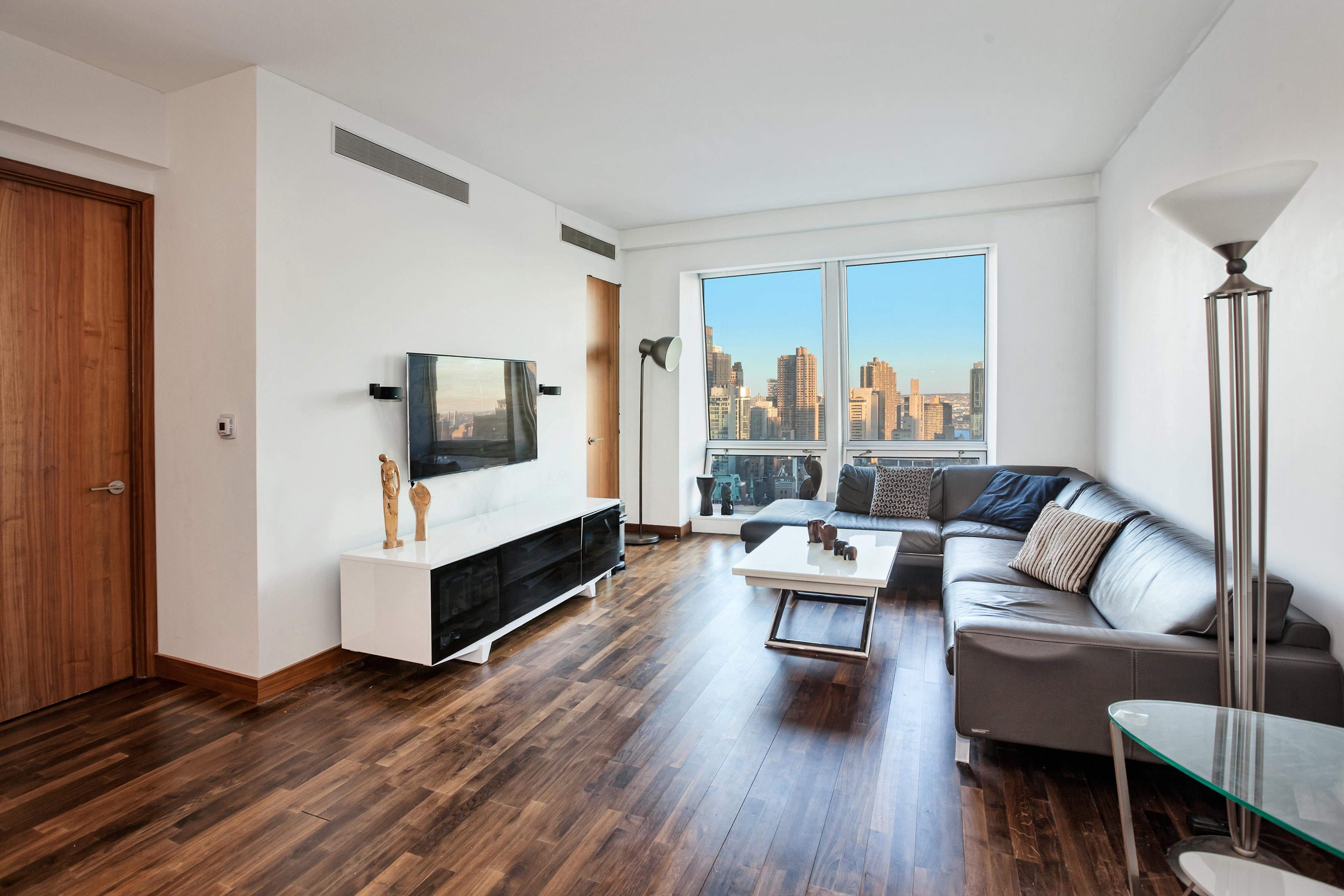 a living room with furniture and a wooden floor