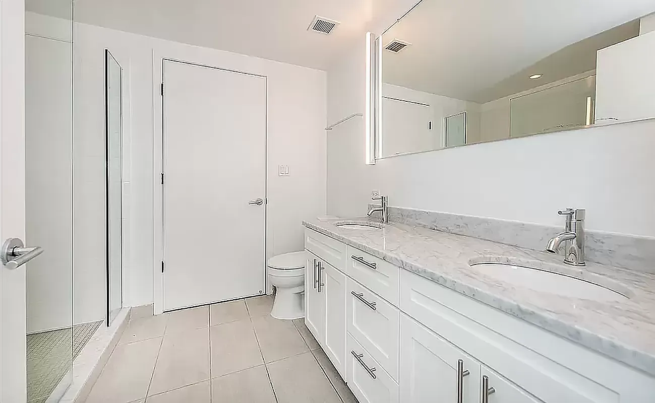 424 Bedford Avenue, Unit 5C Brooklyn, NY 11249 - Photo 4 of 11 a spacious bathroom with a granite countertop sink a toilet and a mirror