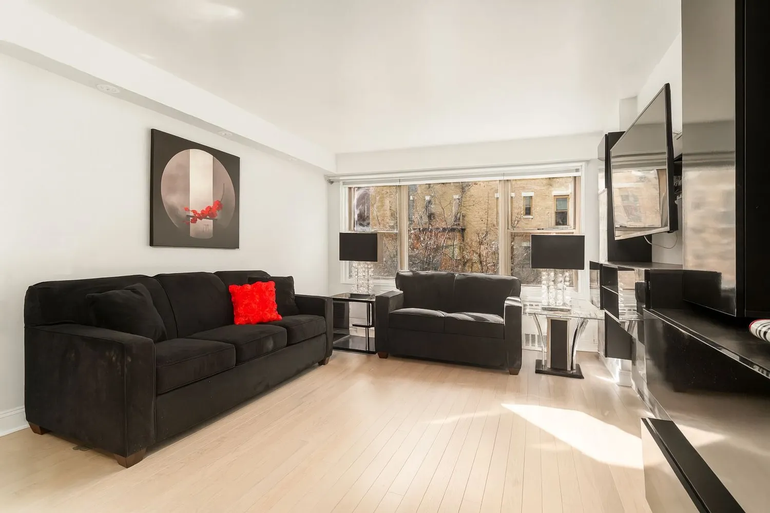 a living room with furniture a large window and a flat screen tv