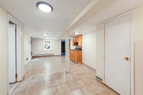 a view of a electric appliances in kitchen and empty room with windows