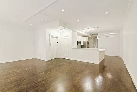a view of a kitchen with wooden floor and a sink