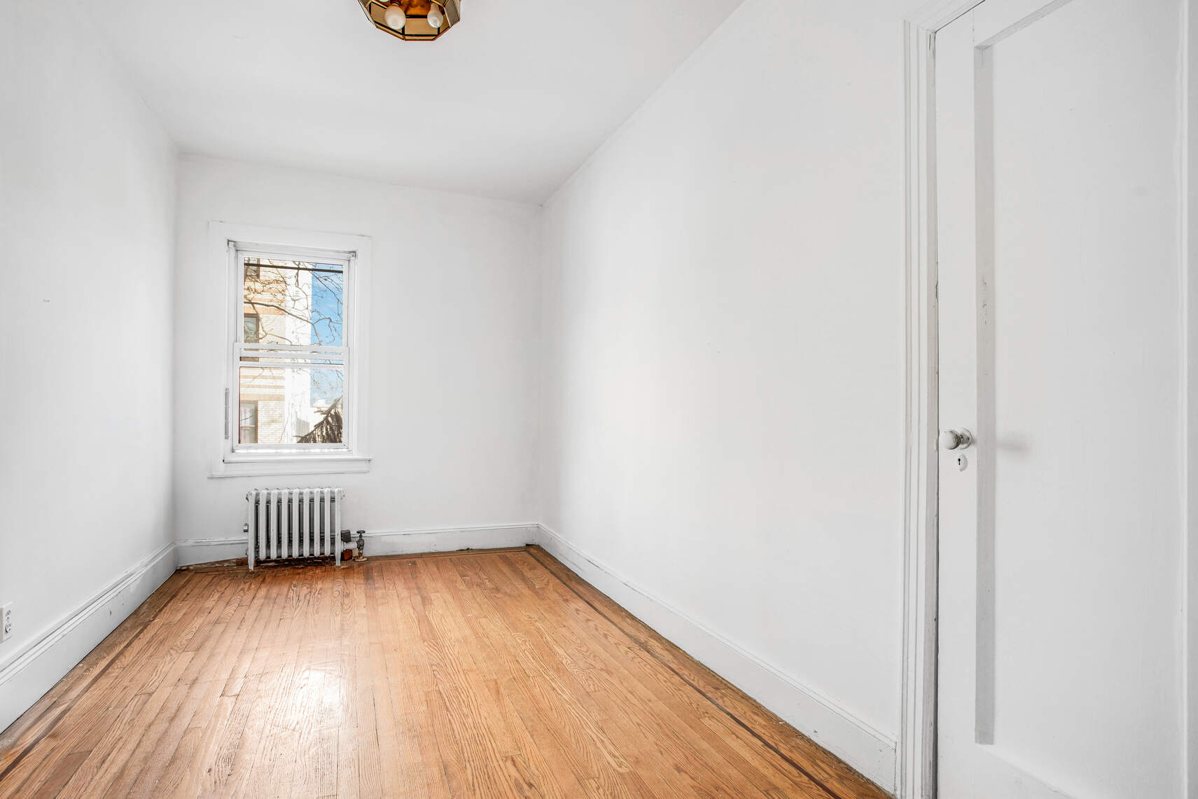 8301 4th Avenue Brooklyn, NY 11209 - Photo 10 of 20 an empty room with wooden floor and windows