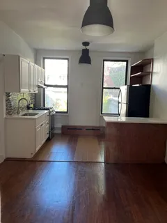 a kitchen with stainless steel appliances granite countertop a dishwasher a stove a sink with wooden floors and cabinets