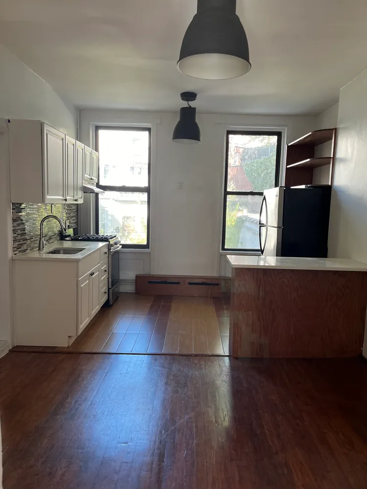 a kitchen with stainless steel appliances granite countertop a dishwasher a stove a sink with wooden floors and cabinets