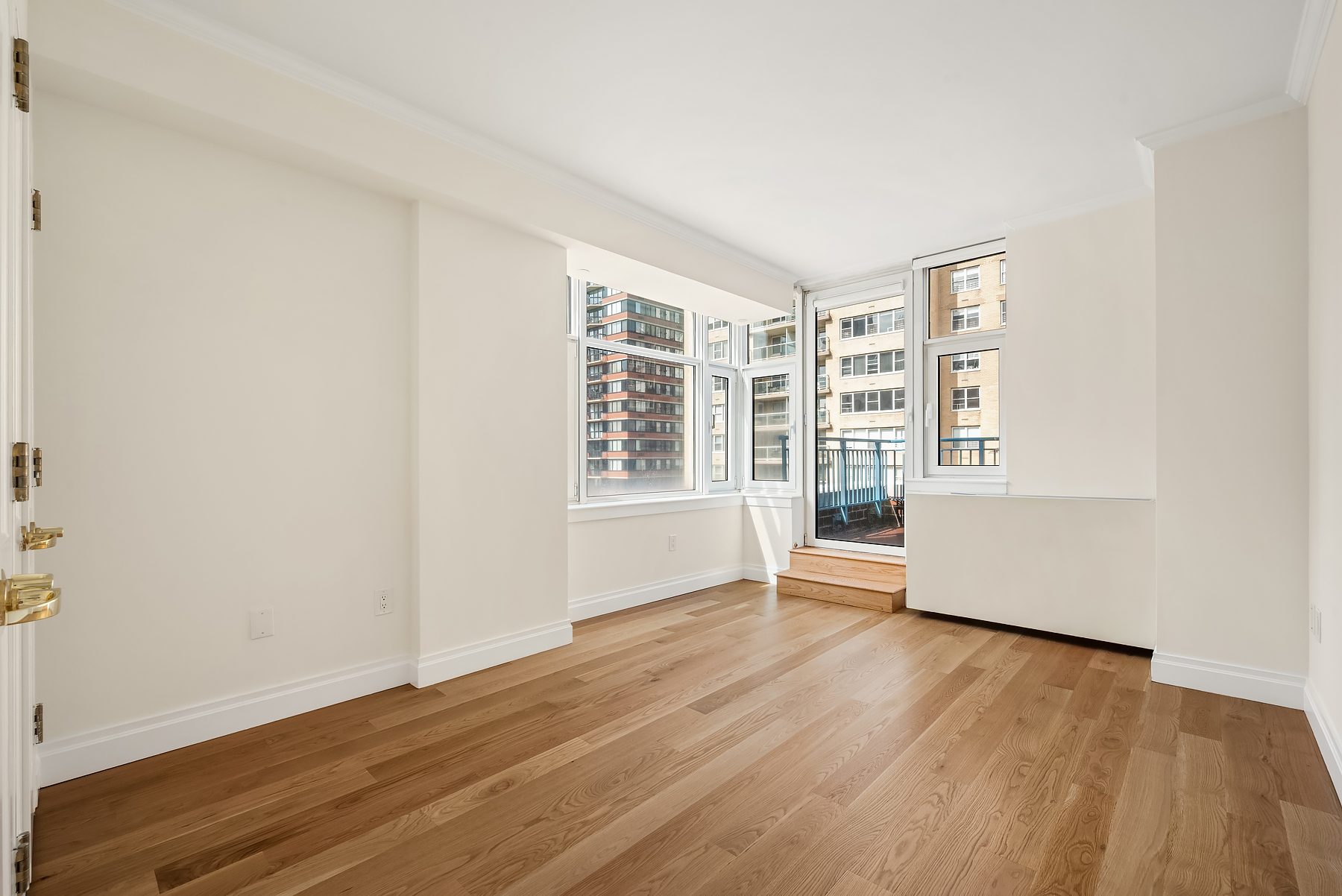 404 East 76th Street, Unit 7C Manhattan, NY 10021 - Photo 4 of 13 an empty room with wooden floor and windows