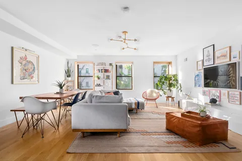 a living room with furniture a flat screen tv and a table