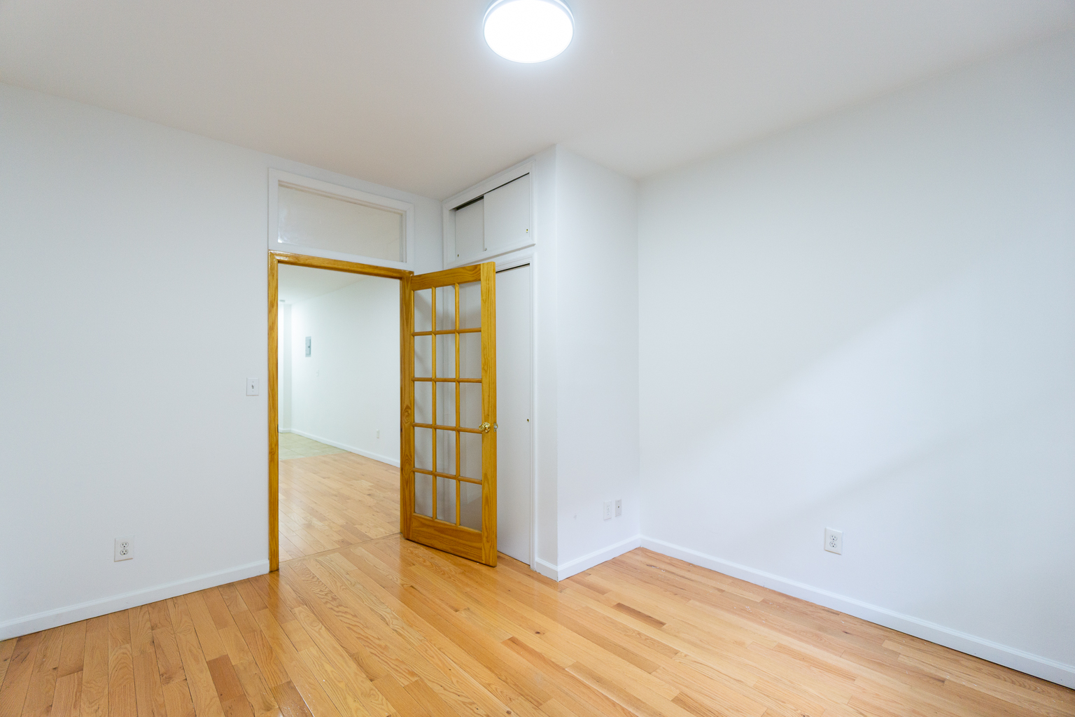 315 East 5th Street, Unit 1C Manhattan, NY 10003 - Photo 8 of 15 an empty room with wooden floor and windows