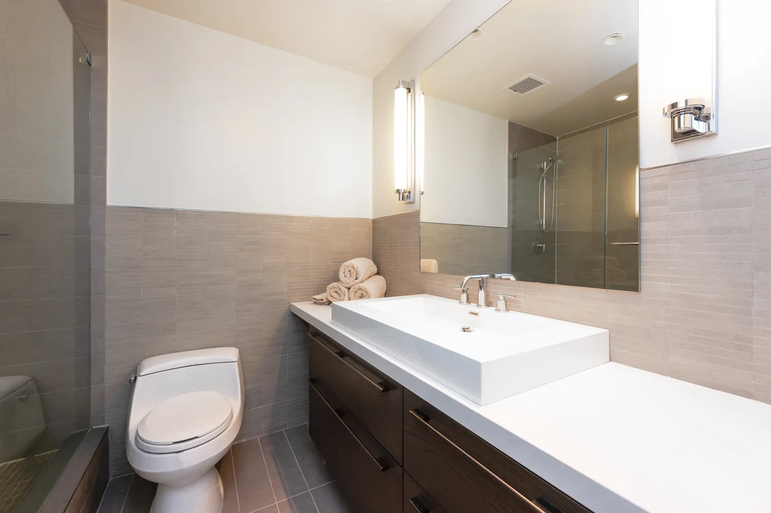 a bedroom with a bed a couch and a flat screen tv