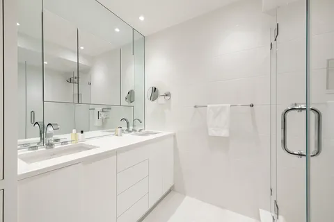 a bathroom with a sink mirror and shower