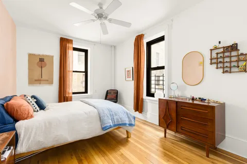 a bedroom with a bed a mirror and a window