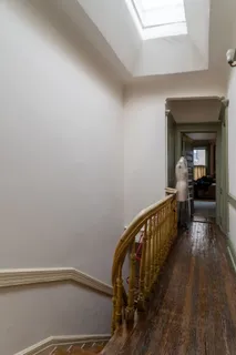 a view of a hallway with wooden floor and staircase