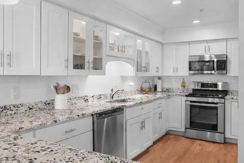 a kitchen with stainless steel appliances granite countertop a sink and stove top oven