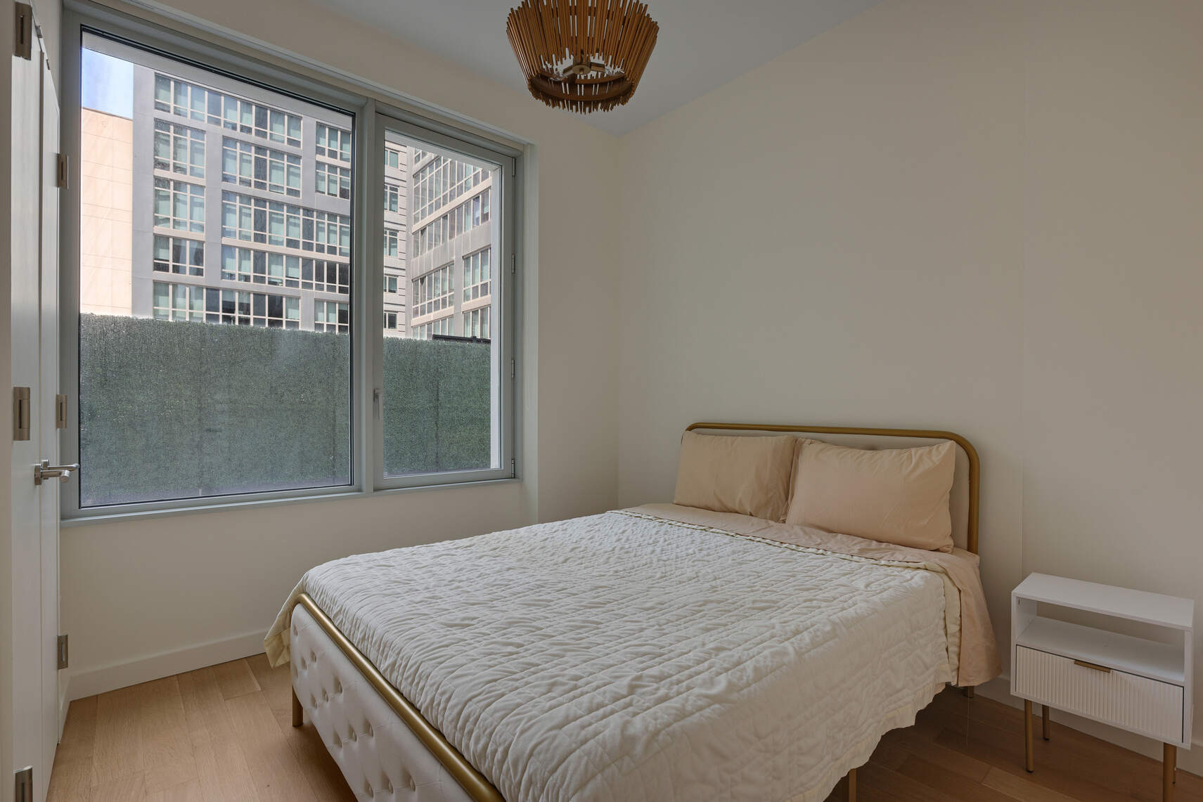 611 West 56th Street, Unit 2D Manhattan, NY 10019 - Photo 3 of 10 a bedroom with a large bed and a window