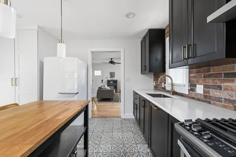 a kitchen with sink stove and cabinets