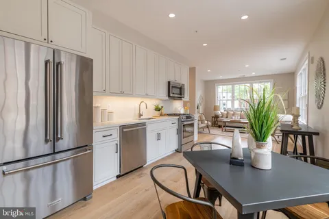 a kitchen with a table chairs refrigerator and microwave