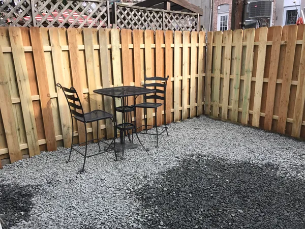 a view of wooden chairs in a backyard