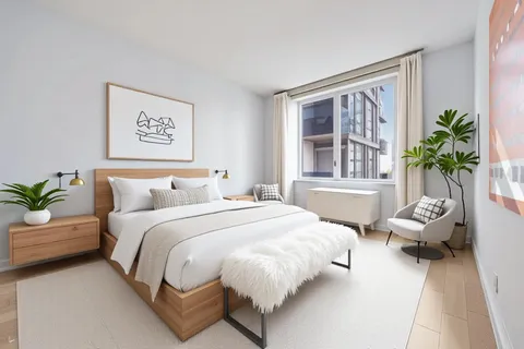 a bed sitting in a bedroom next to a window with potted plants
