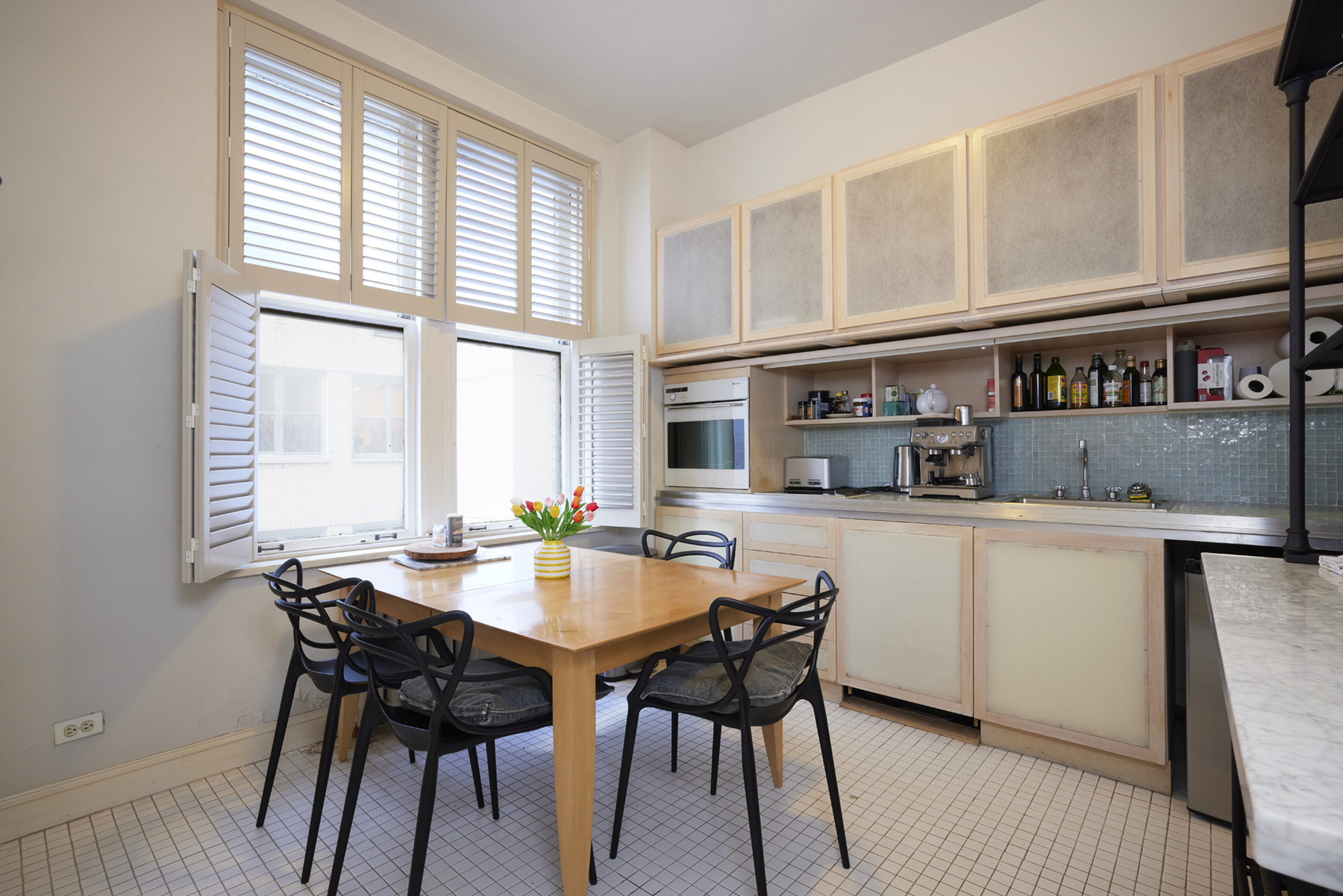 907 5th Avenue, Unit 4F Manhattan, NY 10021 - Photo 4 of 13 a kitchen with a table chairs and wooden floor