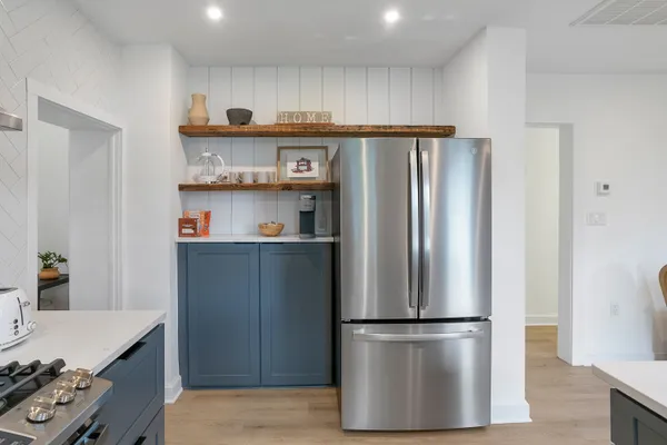 a kitchen with stainless steel appliances a refrigerator and a stove top oven