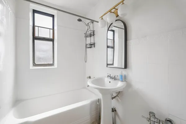 a bathroom with a sink bathtub and a window