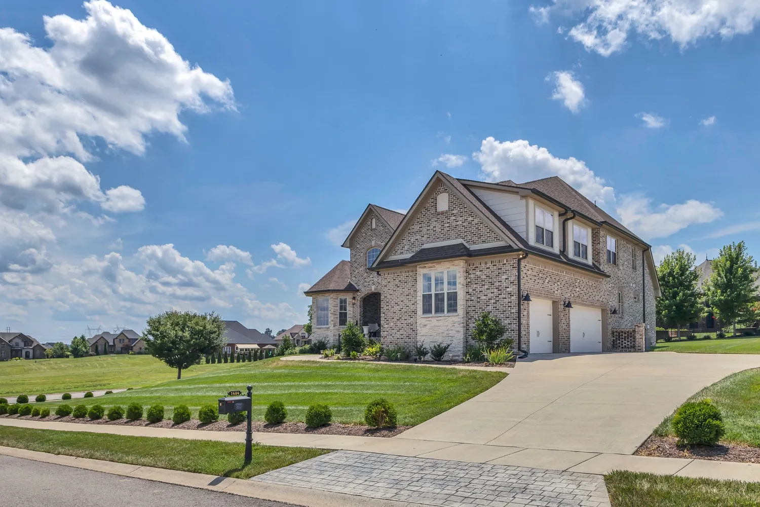 a front view of a house with a yard and road