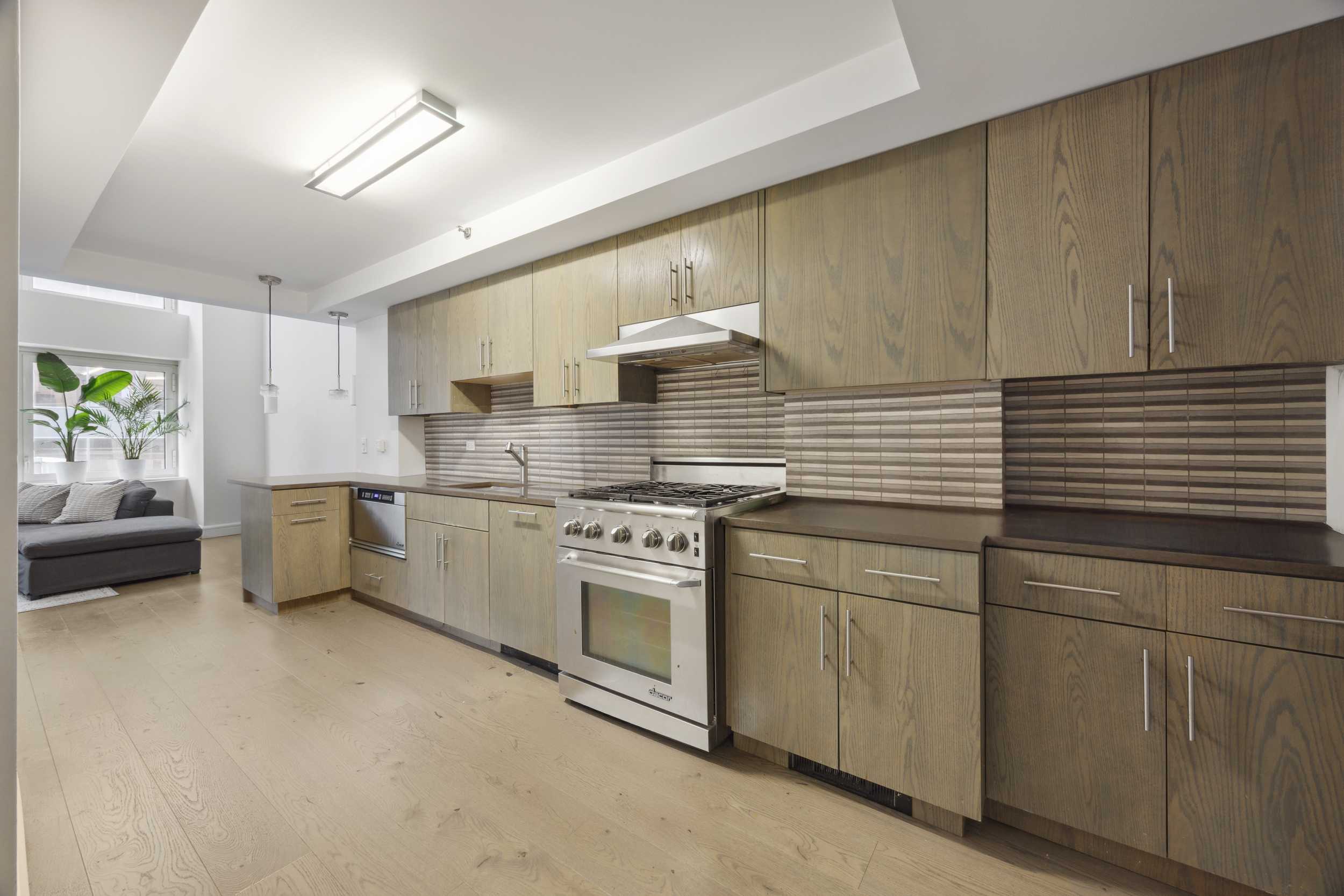 67 Liberty Street, Unit 10 Manhattan, NY 10005 - Photo 3 of 10 a kitchen with stainless steel appliances granite countertop a stove a sink and a refrigerator