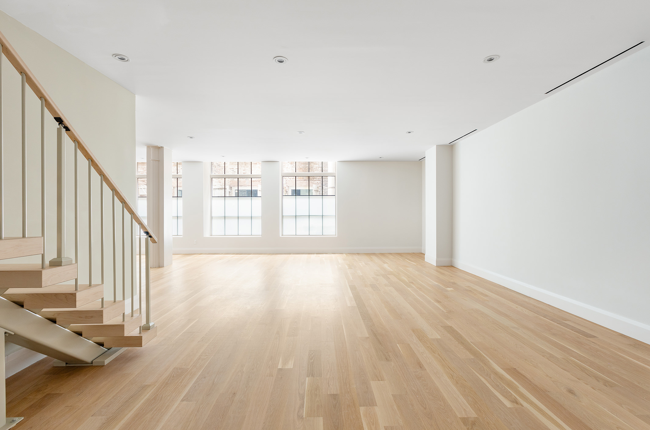66 Reade Street, Unit TH Manhattan, NY 10007 - Photo 13 of 18 a view of an empty room with wooden floor and a window