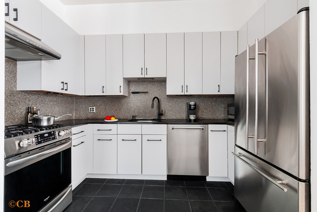 159 Carlton Avenue, Unit 4A Brooklyn, NY 11205 - Photo 6 of 9 a kitchen with stainless steel appliances granite countertop a refrigerator a stove a sink and white cabinets