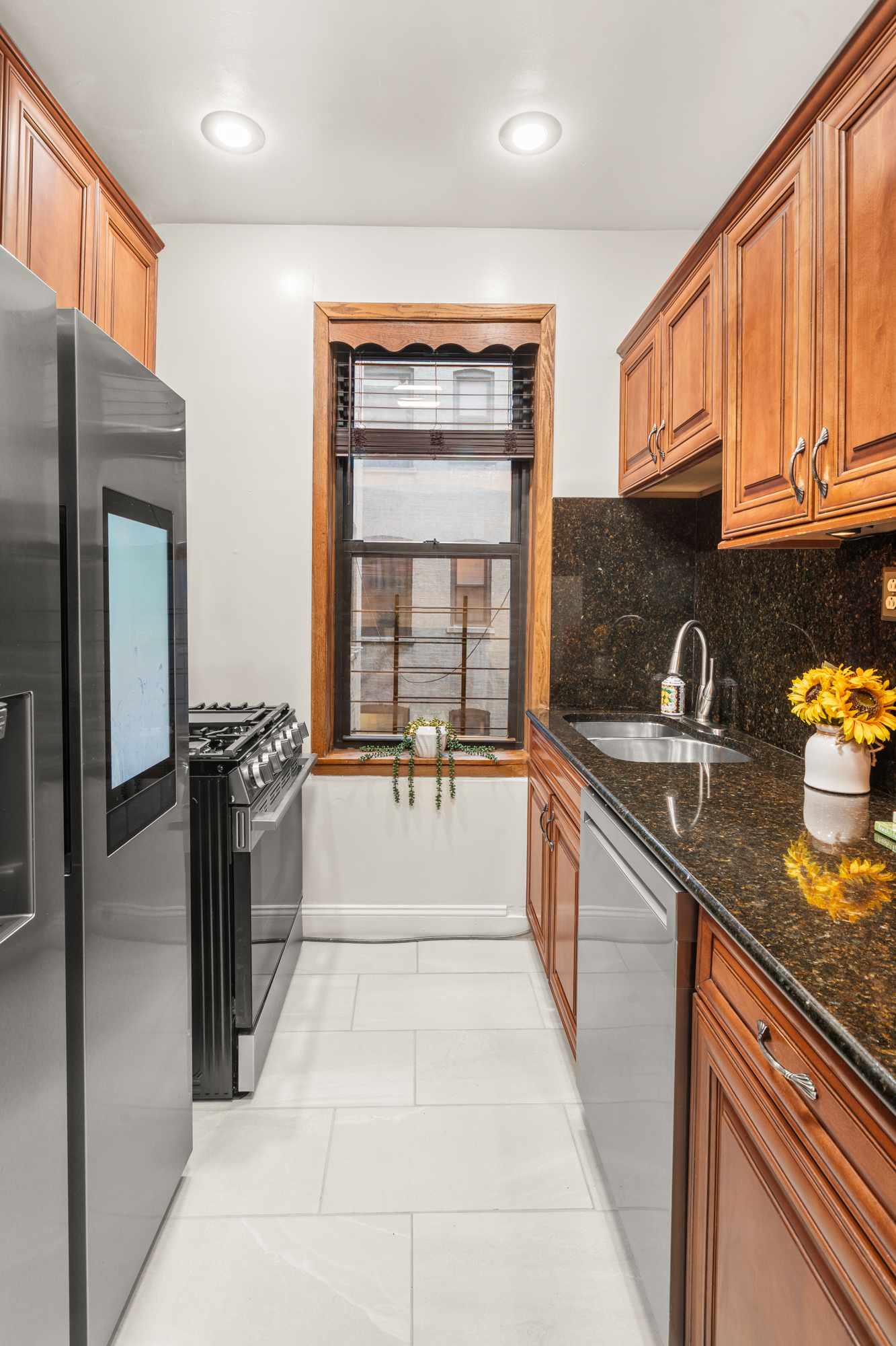 527 West 143rd Street, Unit 31 Manhattan, NY 10031 - Photo 8 of 29 a large kitchen with stainless steel appliances granite countertop a refrigerator and a sink