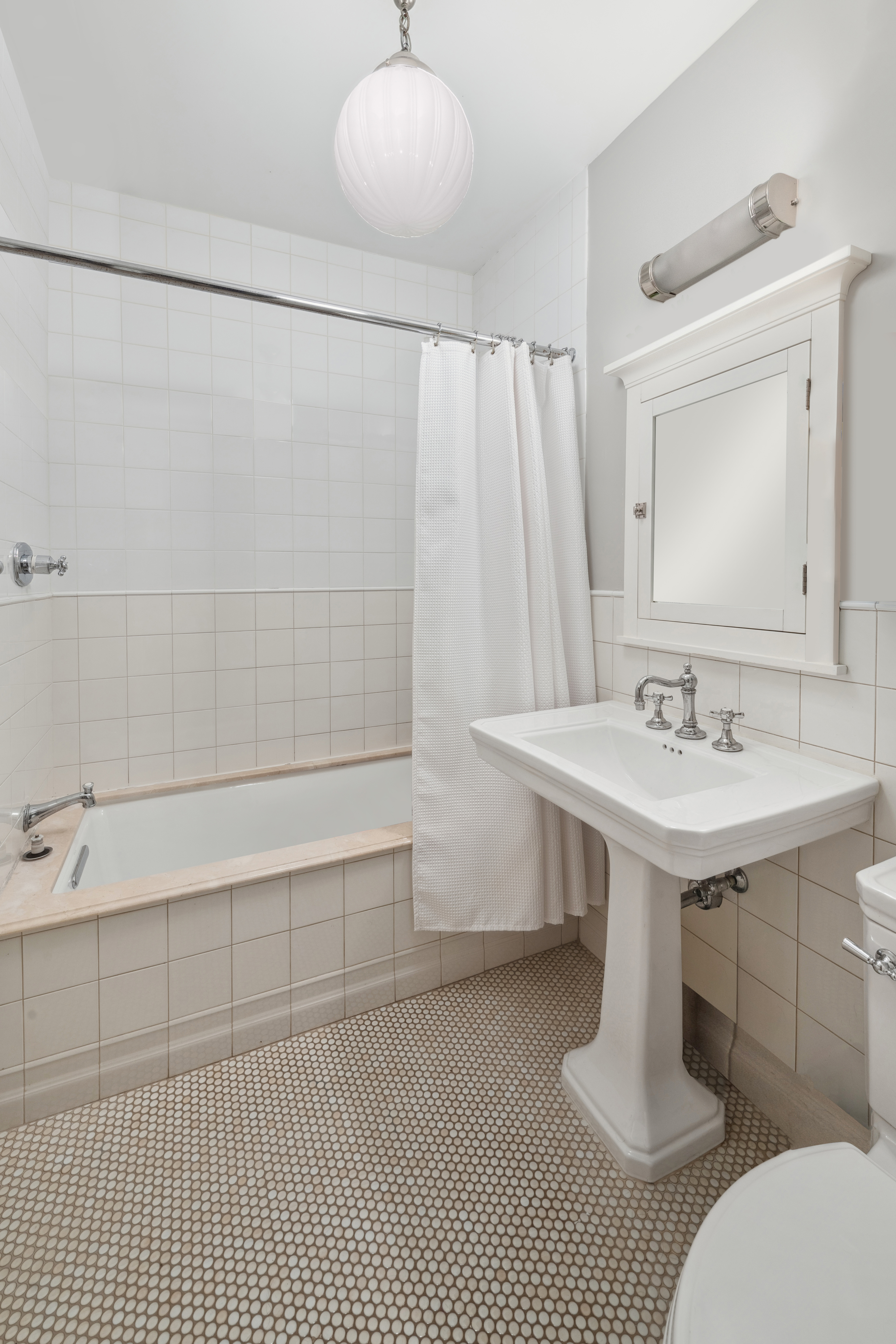 240 East 62nd Street Manhattan, NY 10065 - Photo 11 of 12 a bathroom with a sink a toilet and shower
