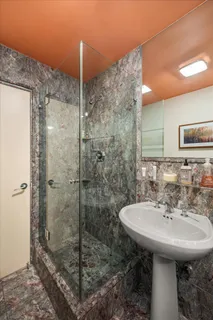 a bathroom with a sink shower and a mirror