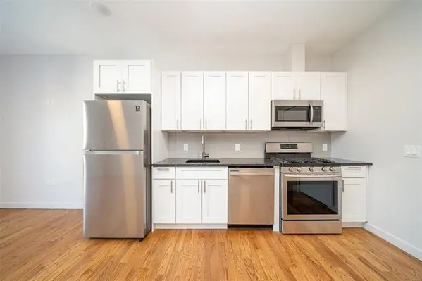 a kitchen with stainless steel appliances a refrigerator stove and microwave