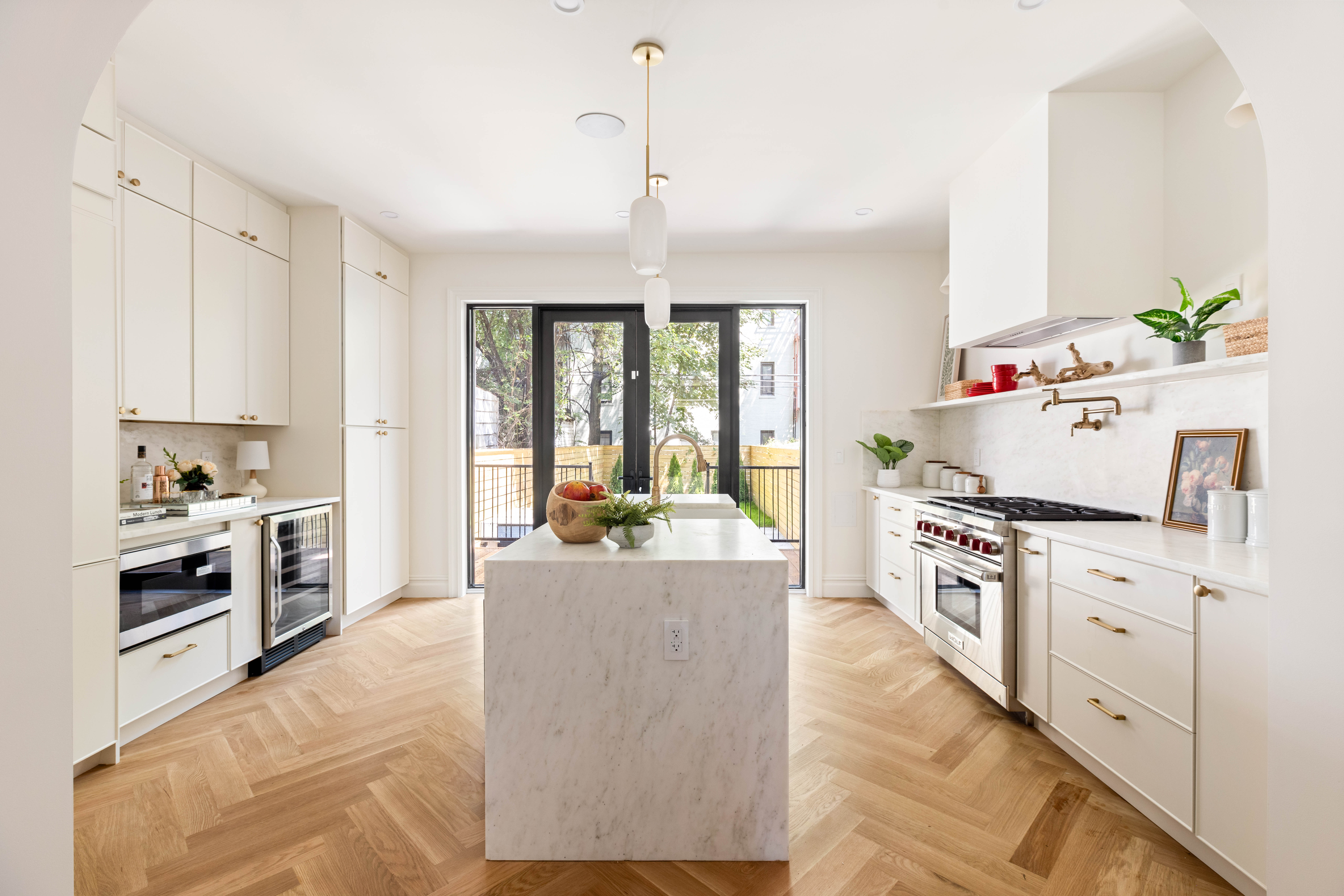287 Midwood Street Brooklyn, NY 11225 - Photo 5 of 17 a kitchen with kitchen island a stove a sink and white cabinets with wooden floor