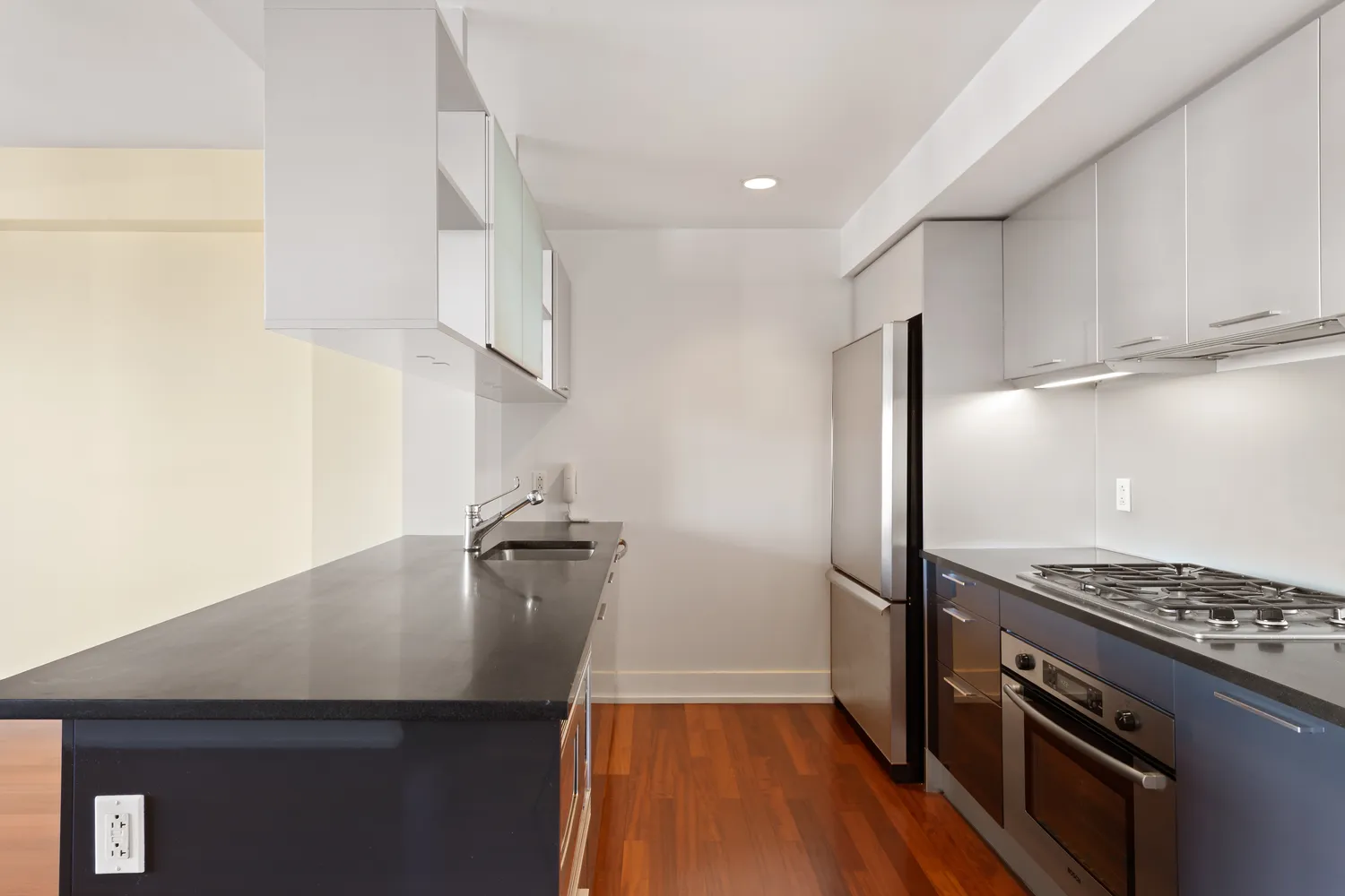 a kitchen with wooden floor and stainless steel appliances
