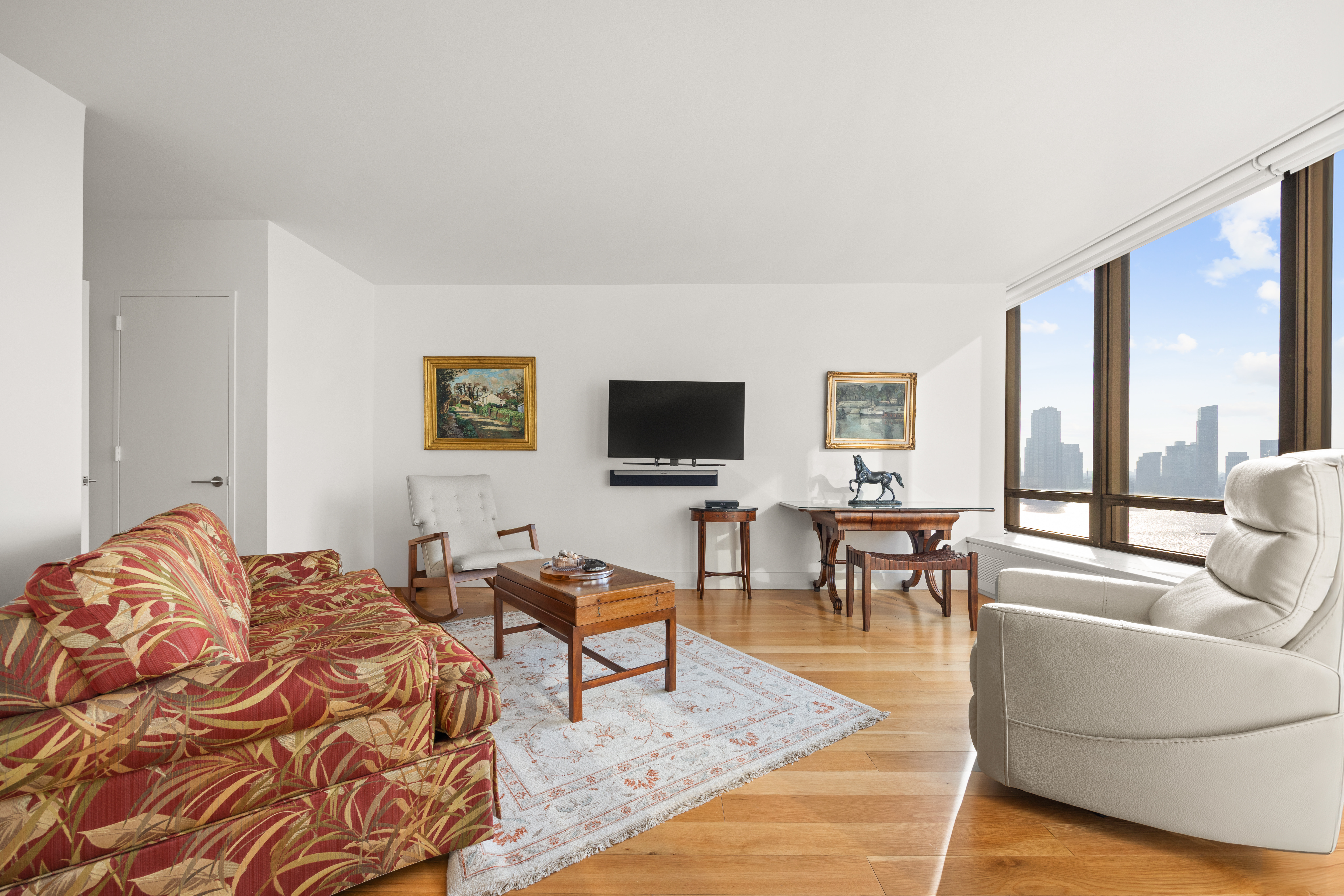 860 United Nations Plaza, Unit 16G Manhattan, NY 10017 - Photo 9 of 12 a living room with furniture and a flat screen tv