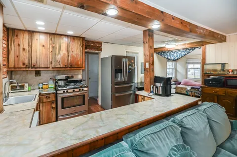 a kitchen with stainless steel appliances granite countertop a stove a sink and a refrigerator