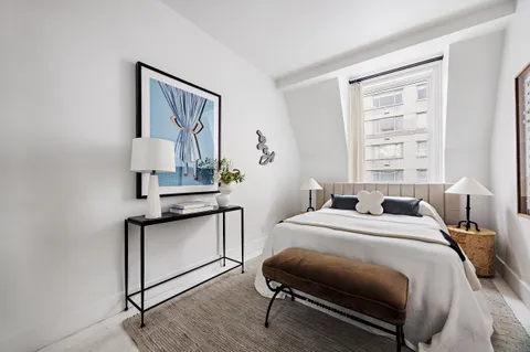 a bedroom with a bed a mirror and a window