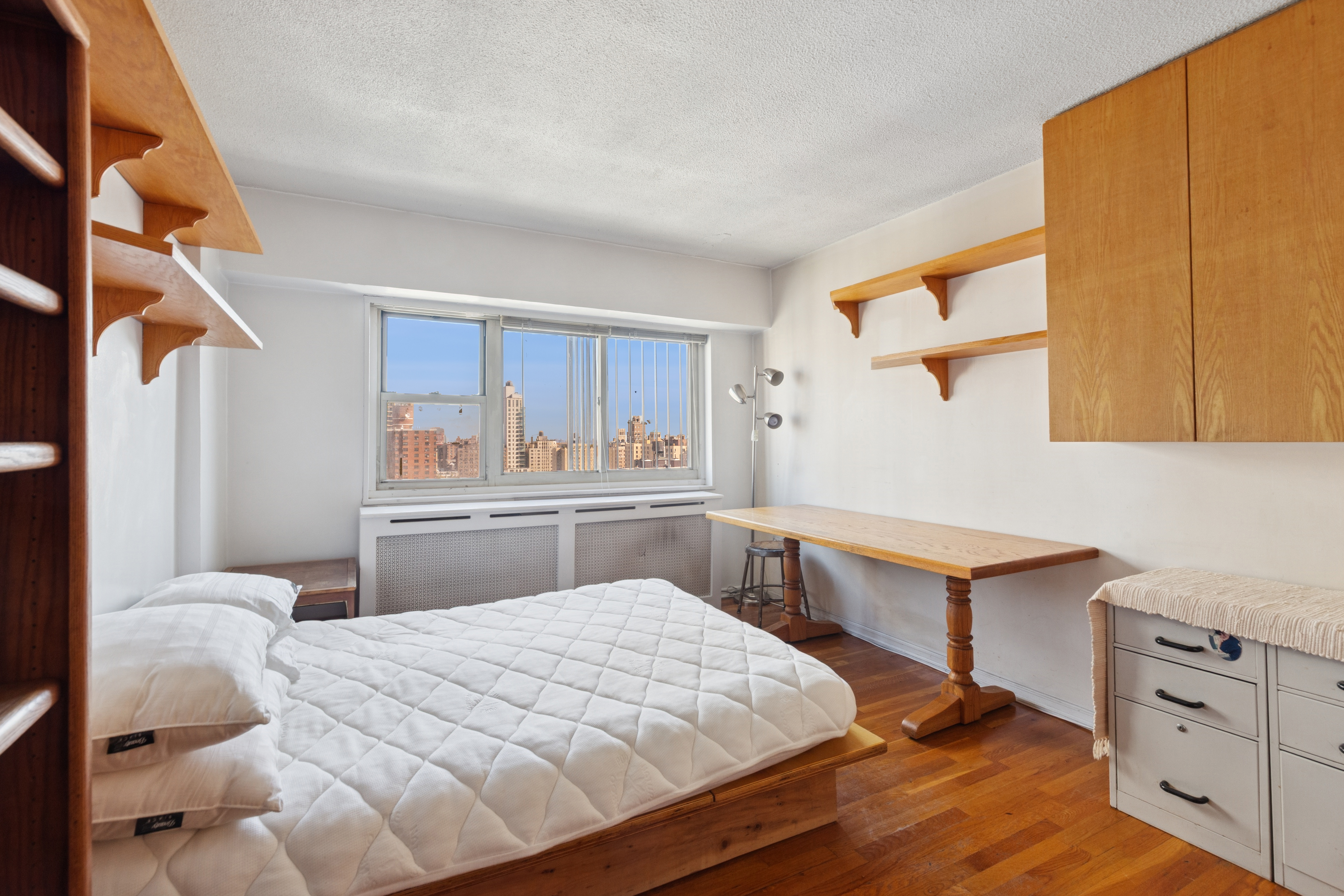 609 Columbus Avenue, Unit 18E Manhattan, NY 10024 - Photo 7 of 10 a bedroom with a bed and a table in it