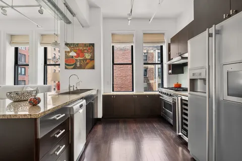 a kitchen with stainless steel appliances granite countertop a refrigerator and a stove top oven