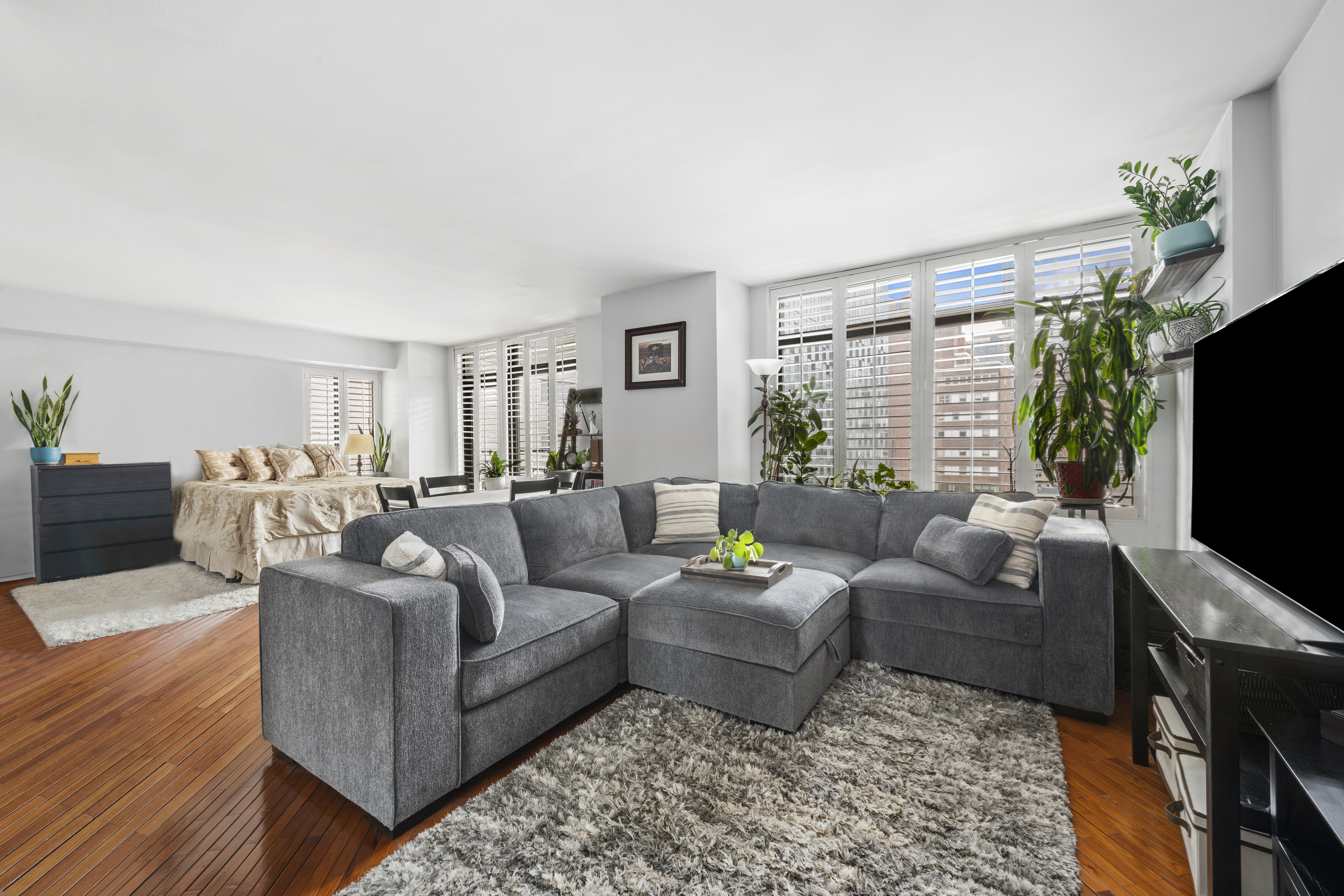 400 East 70th Street, Unit 1108 Manhattan, NY 10021 - Photo 2 of 8 a living room with furniture and a flat screen tv