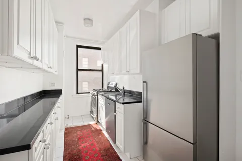 a kitchen with stainless steel appliances granite countertop a refrigerator and a stove
