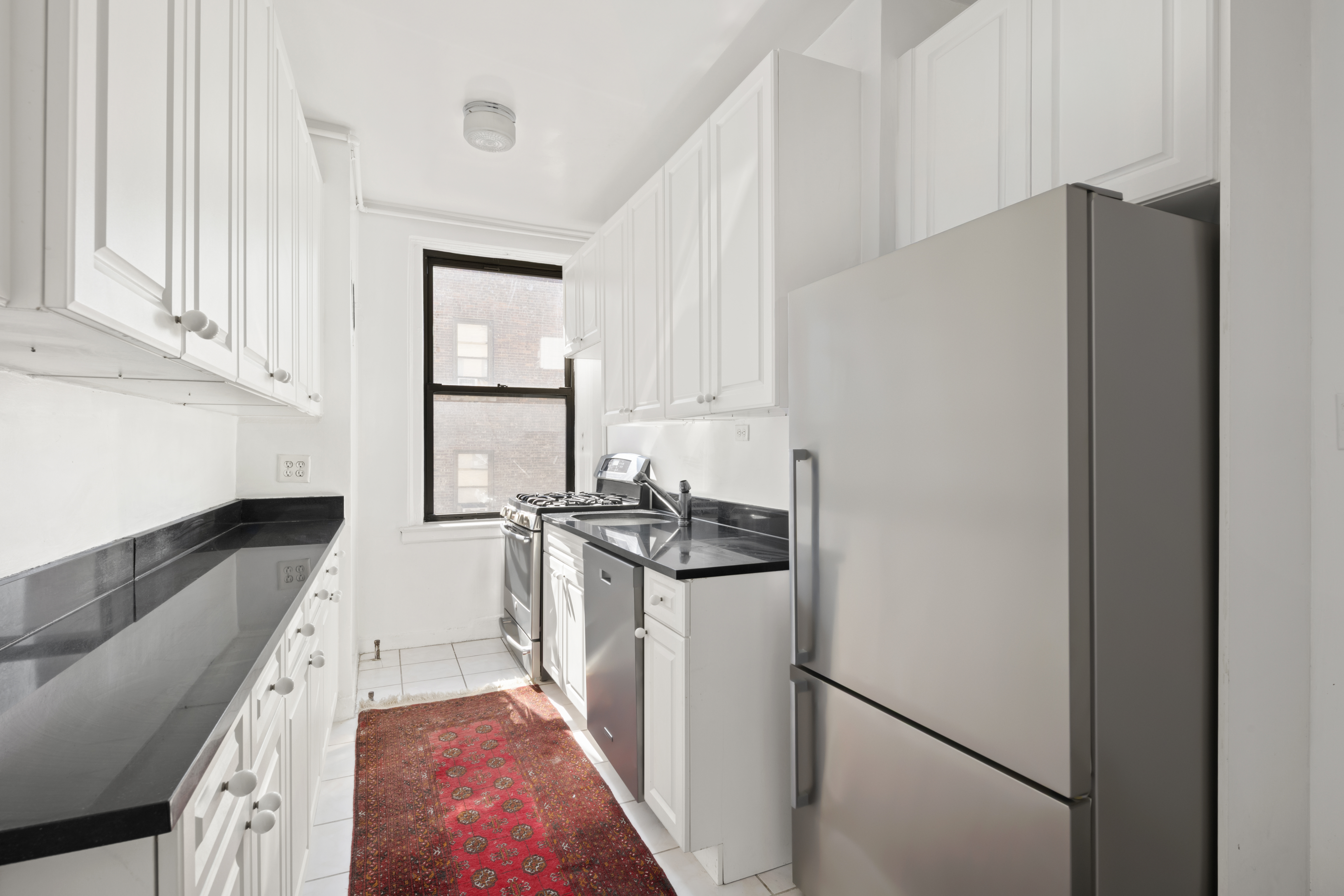 473 West End Avenue, Unit 13D Manhattan, NY 10024 - Photo 8 of 13 a kitchen with stainless steel appliances granite countertop a refrigerator and a stove