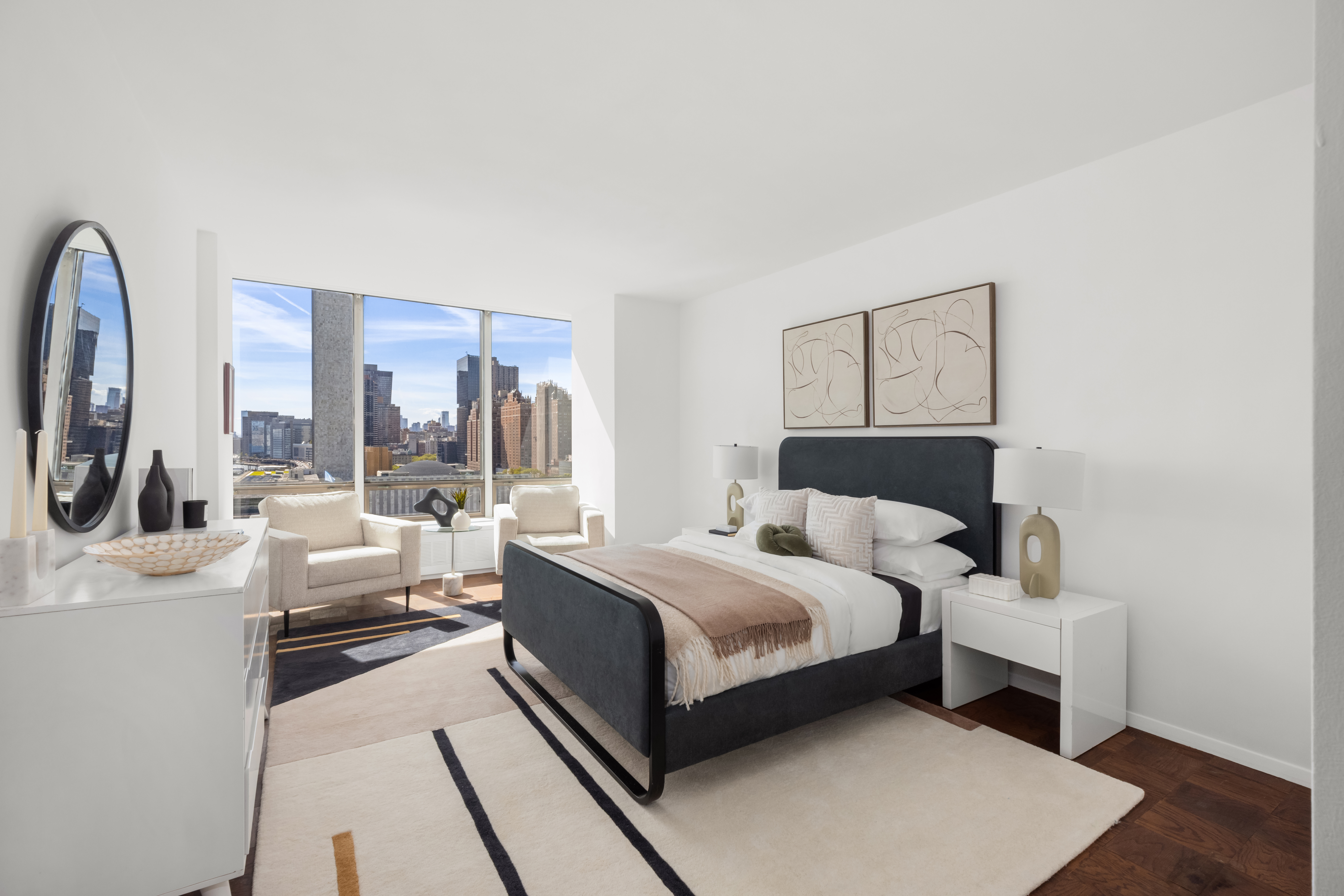 870 United Nations Plaza, Unit 14F Manhattan, NY 10017 - Photo 7 of 16 a bedroom with a large bed and a large window