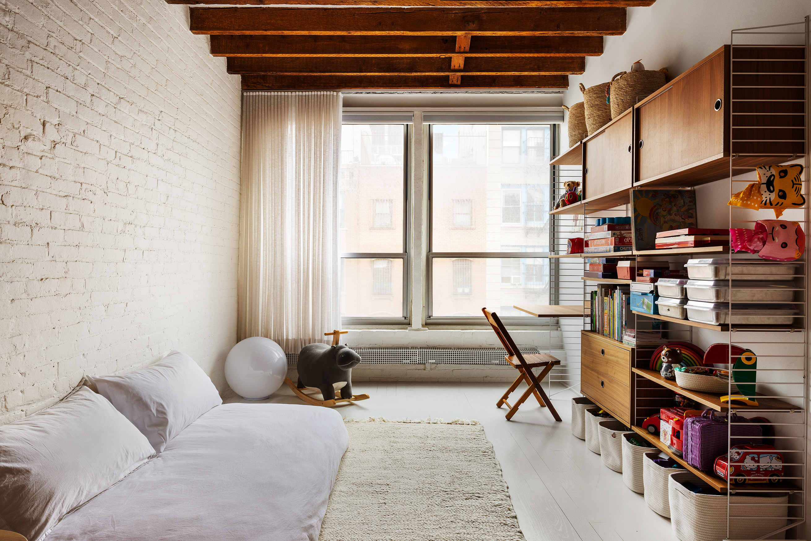 48 Canal Street, Unit 4 Manhattan, NY 10002 - Photo 10 of 13 a living room with lots of furniture and a book shelf