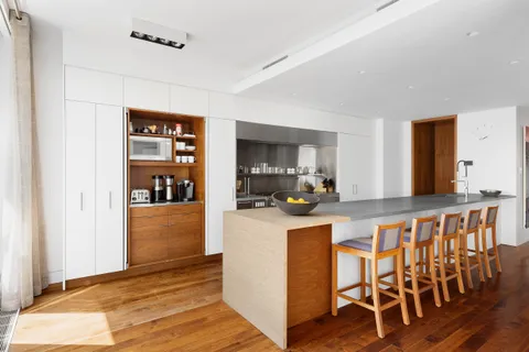 a kitchen with stainless steel appliances a dining table chairs and wooden floor
