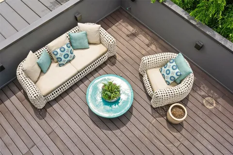 a view of a deck with couches table and chairs with wooden floor and fence