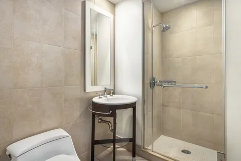 a bathroom with a sink a toilet and shower
