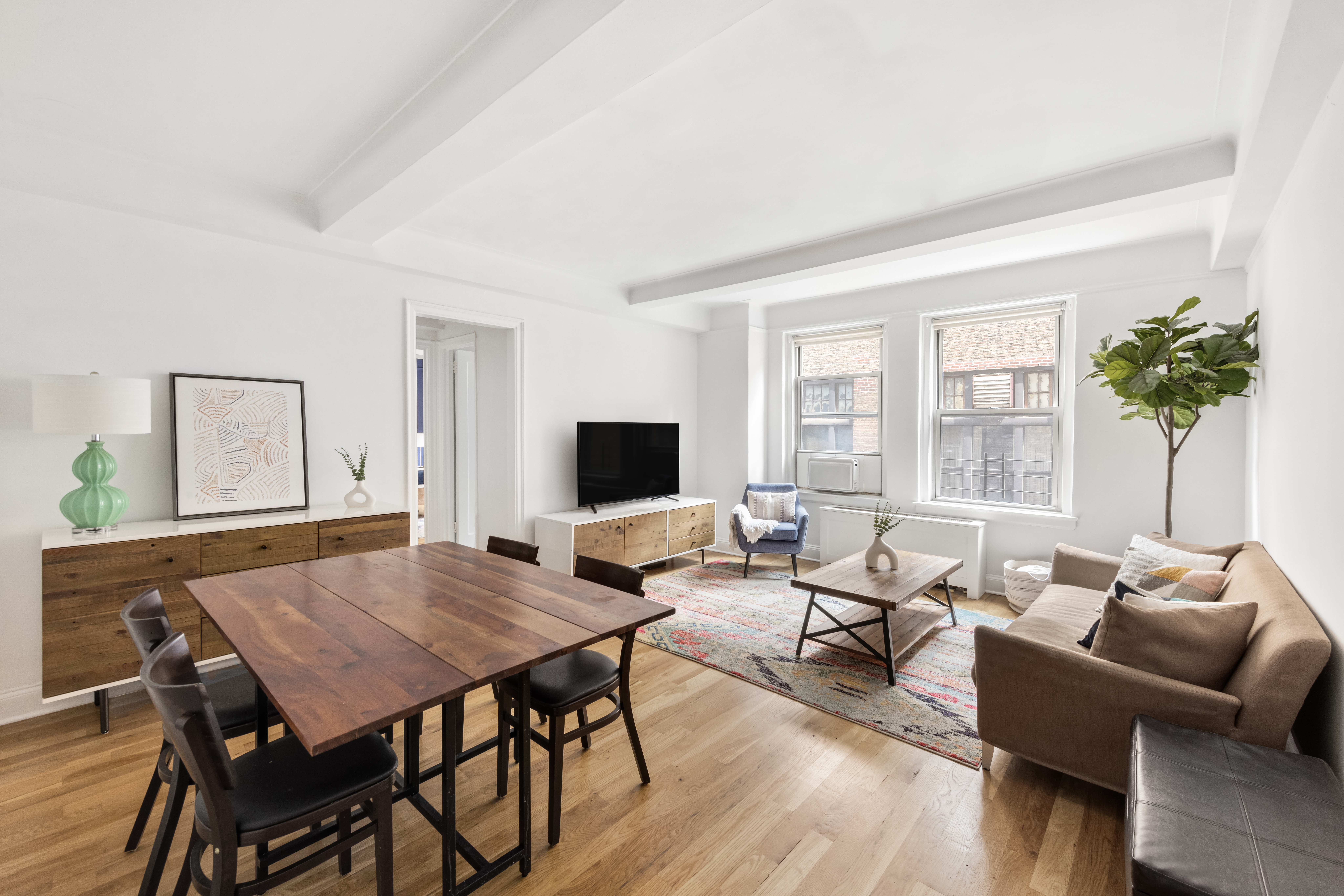 425 East 86th Street, Unit 2F Manhattan, NY 10028 - Photo 1 of 11 a living room with furniture and a flat screen tv