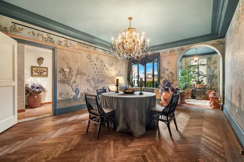 a view of a dining room with furniture a chandelier and wooden floor